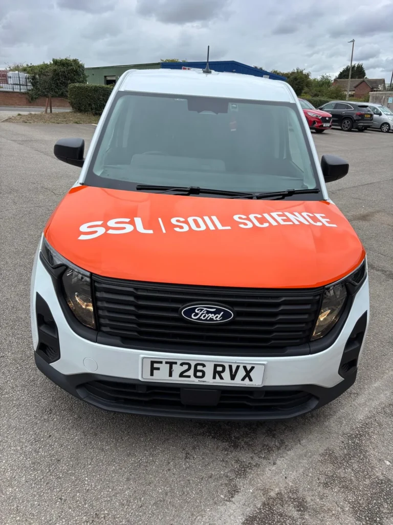 Orange wrapped bonnet on an SSL Soil Science van with white brand lettering